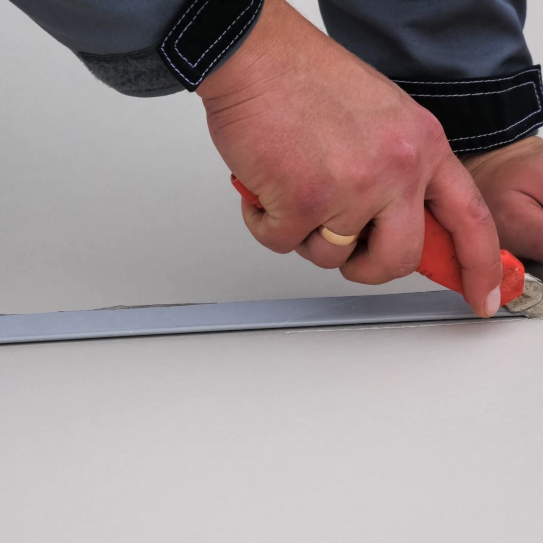 a man cutting an insulation board