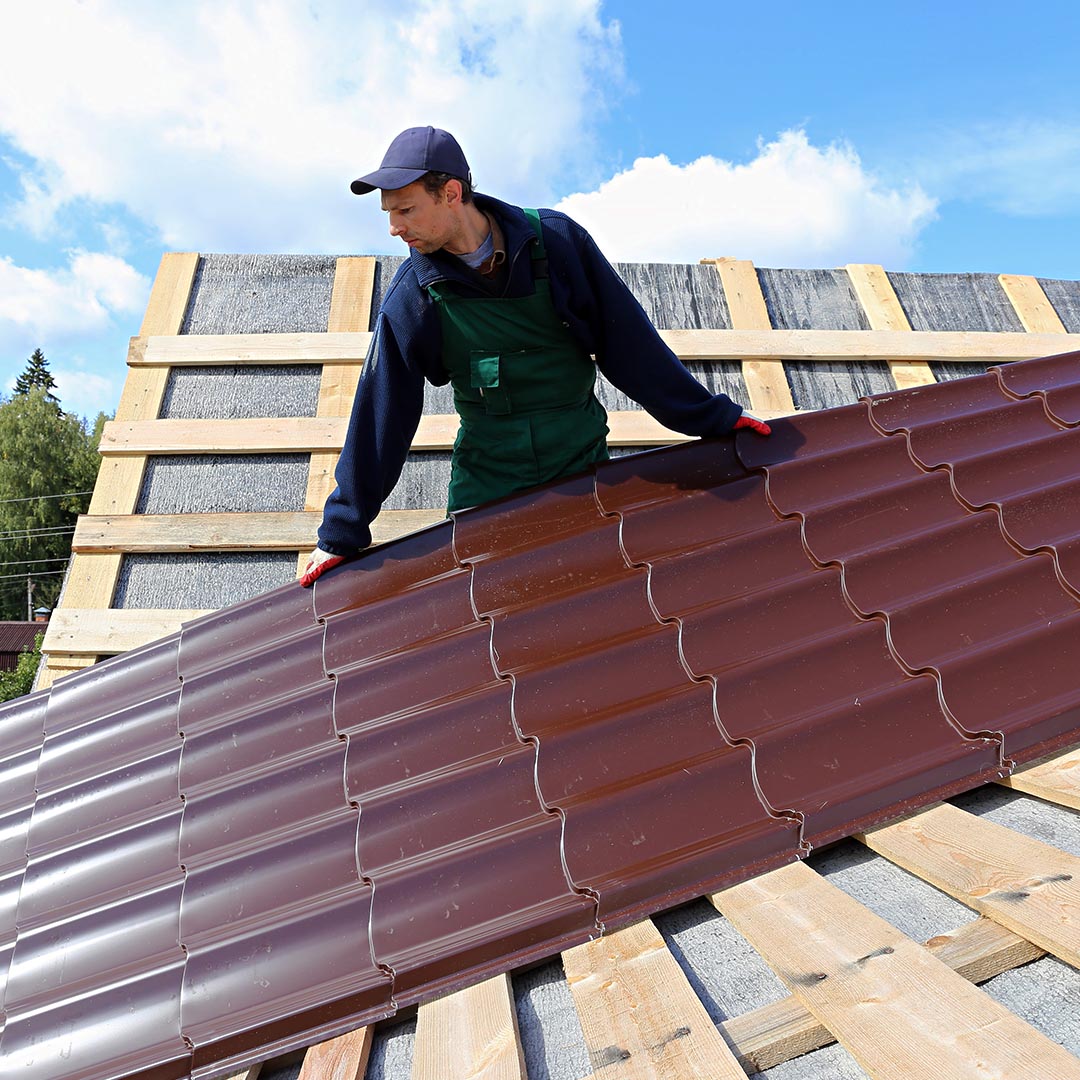 Roof installing a red, metal roof